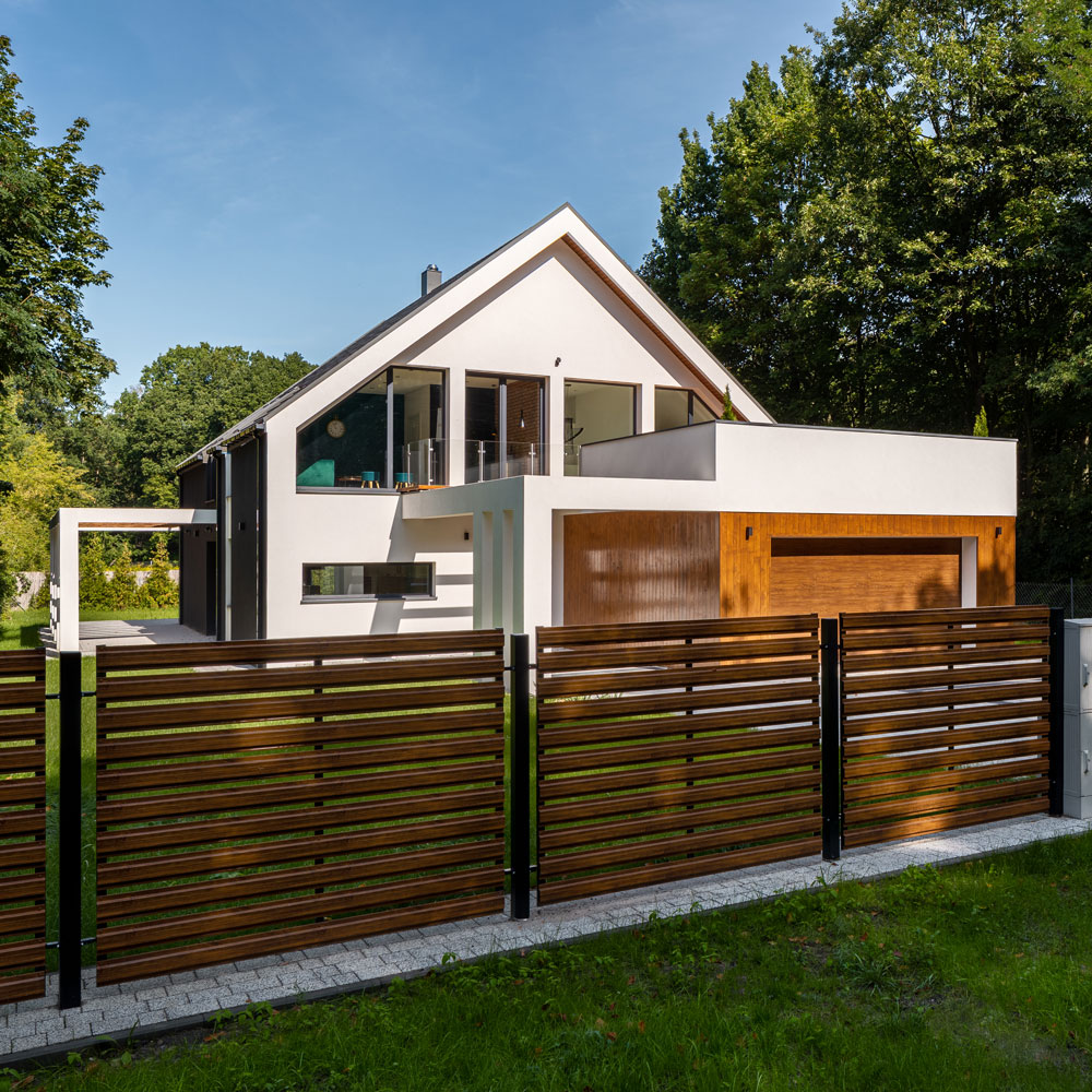 Nybyggt hus med stora fönster och garage